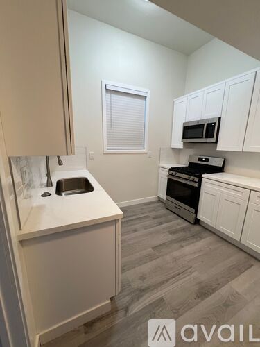A kitchen with a sink and a microwave.