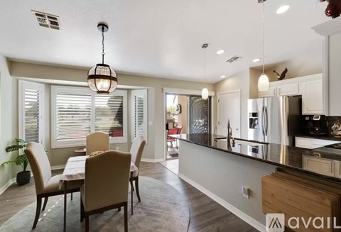 A kitchen with a table and chairs in front of it.