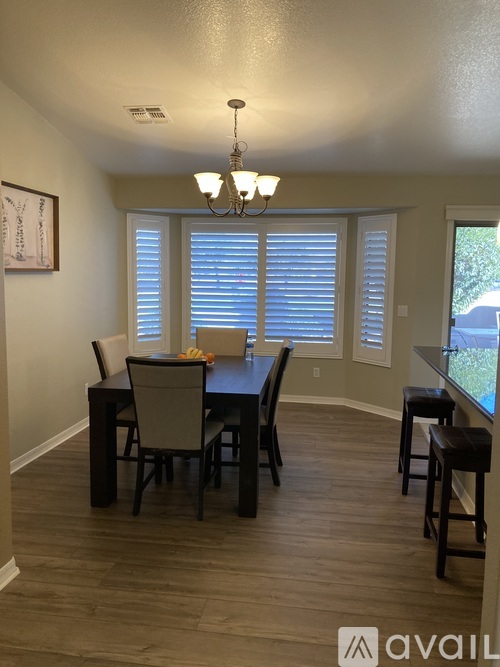 A dining room with a table and chairs.