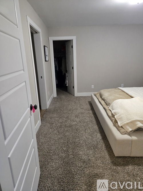 A bedroom with a bed and a carpeted floor.