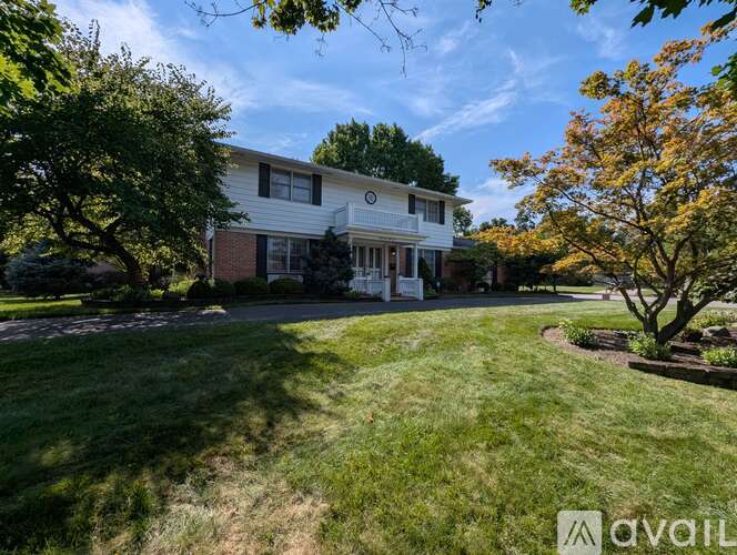 A house with a lawn and trees in front of it.