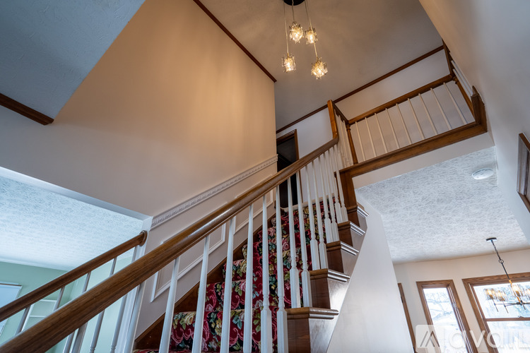 A staircase with a wooden handrail and a skirting board.