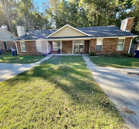 A house with a brick exterior and a covered patio.