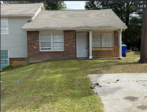 A house with a white door and a brick wall.