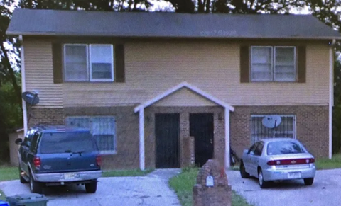 A house with a car and a truck parked in front.