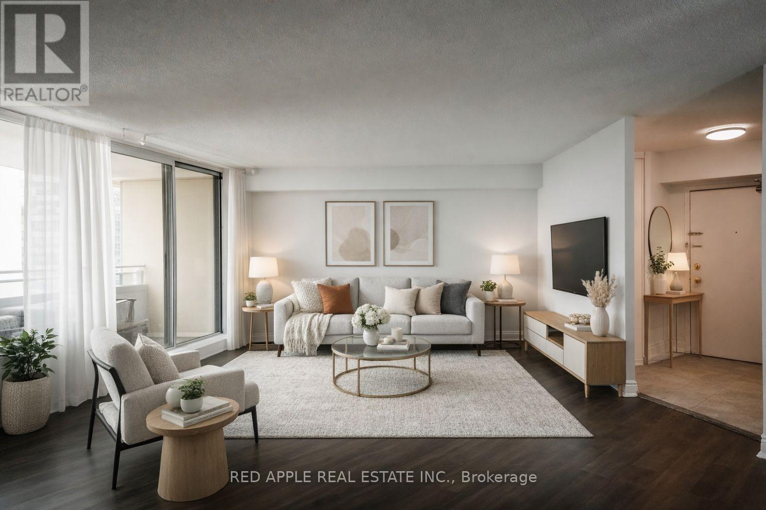 A modern living room with a white sofa, a coffee table, and a TV on the wall.