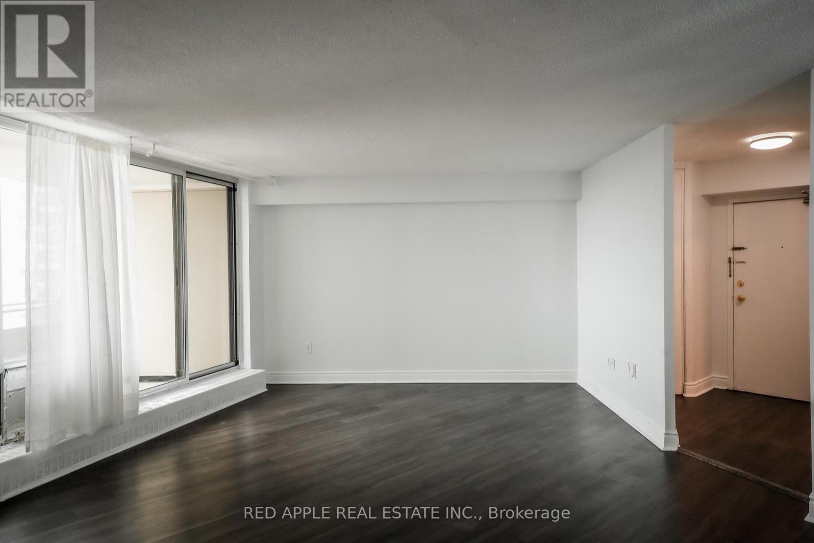 A room with a window and a door is on the market with Red Apple Real Estate Inc.