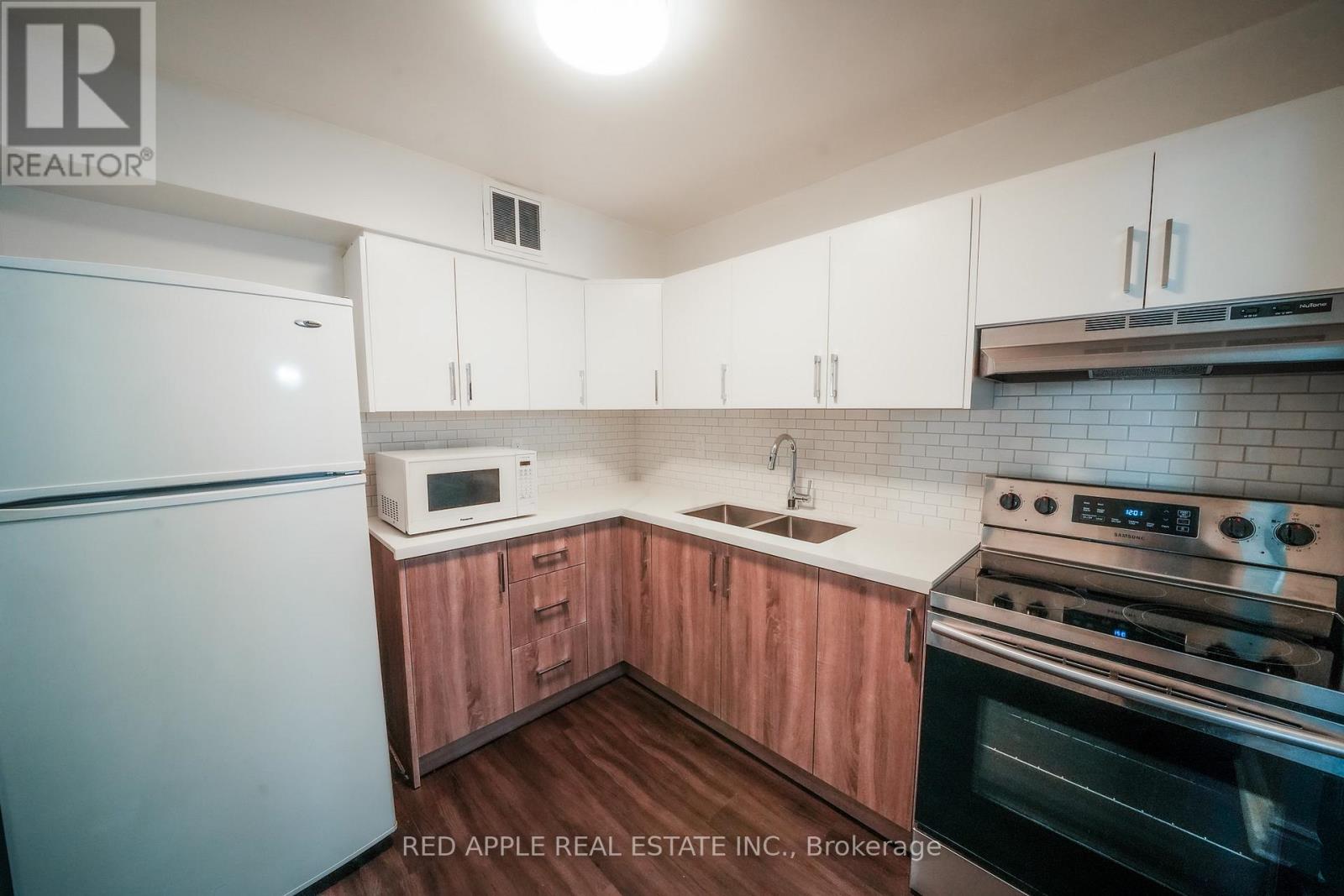 A kitchen with wooden cabinets and a stainless steel oven.