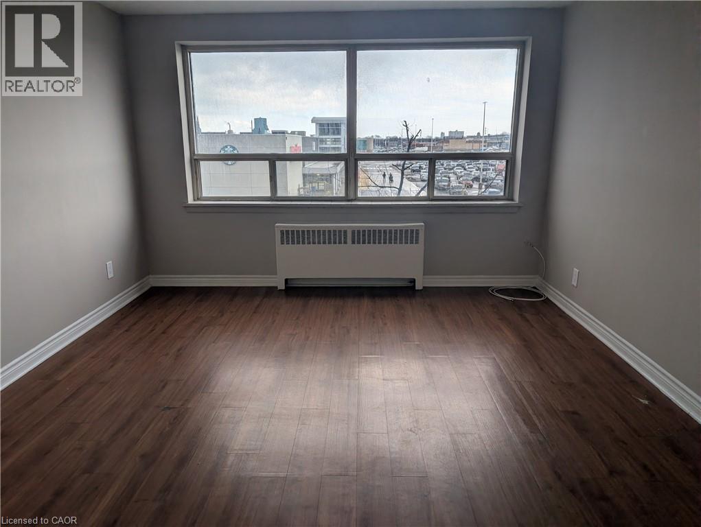 A room with a window and a radiator on the floor.