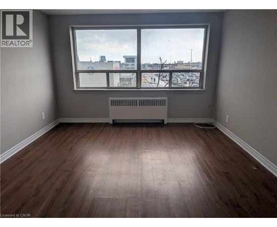A room with a window and a radiator on the floor.