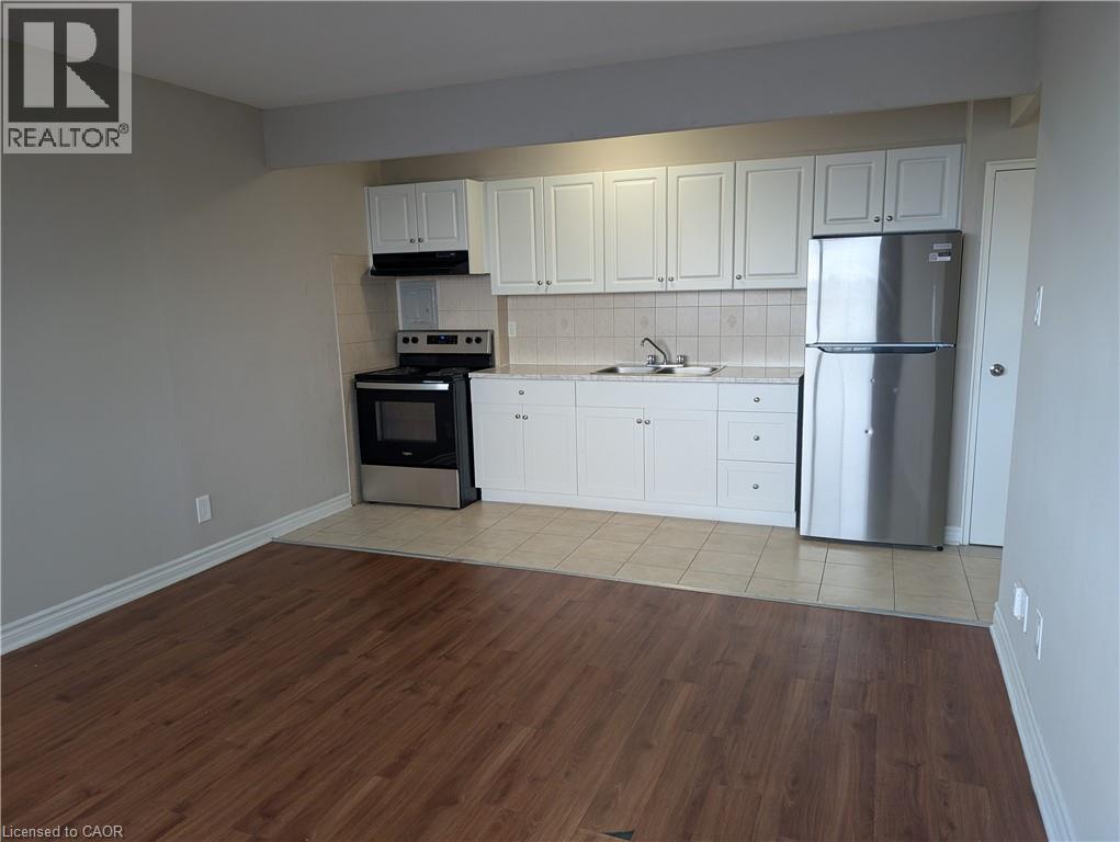 A kitchen with white cabinets and a wooden floor.