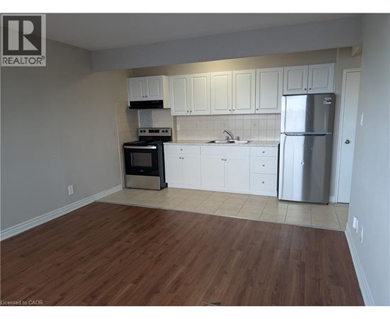 A kitchen with white cabinets and a wooden floor.