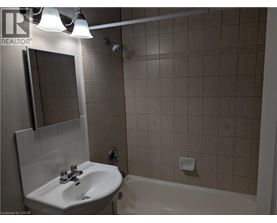 A bathroom with a sink, mirror, and bathtub.