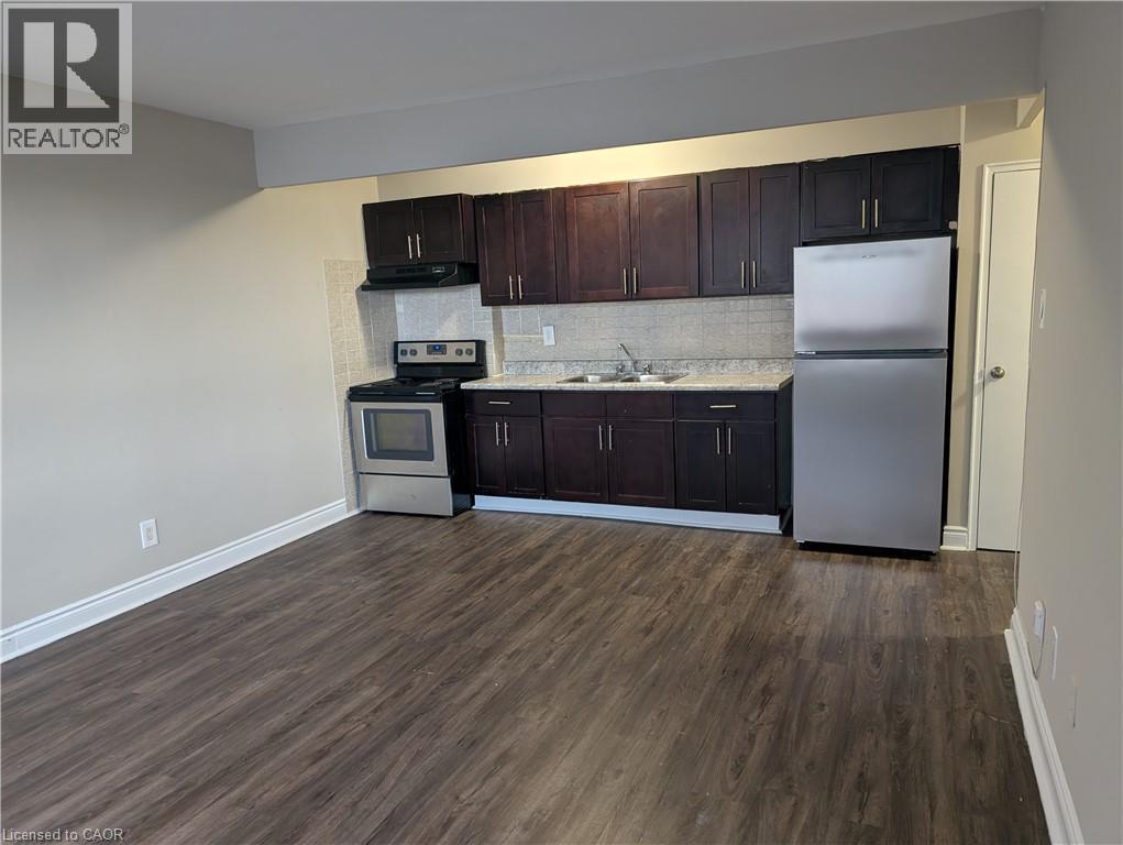 A kitchen with dark wood cabinets and a white fridge.