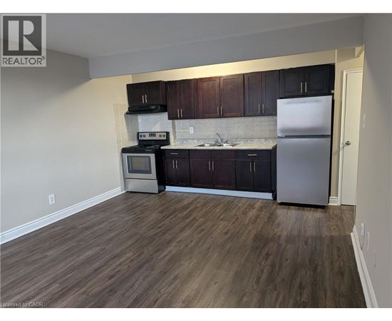A kitchen with dark wood cabinets and a white fridge.