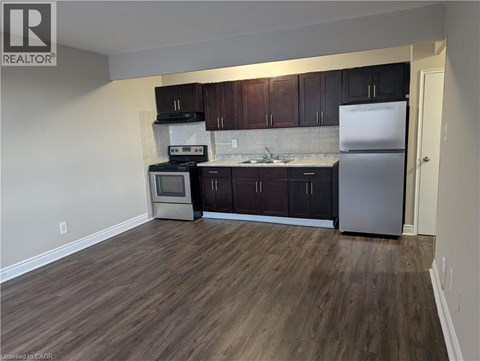 A kitchen with dark wood cabinets and a white fridge.