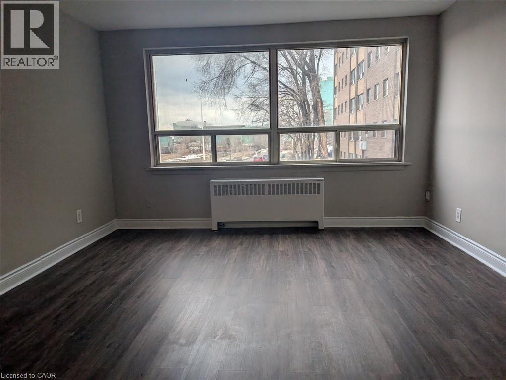A room with a large window and a radiator on the floor.