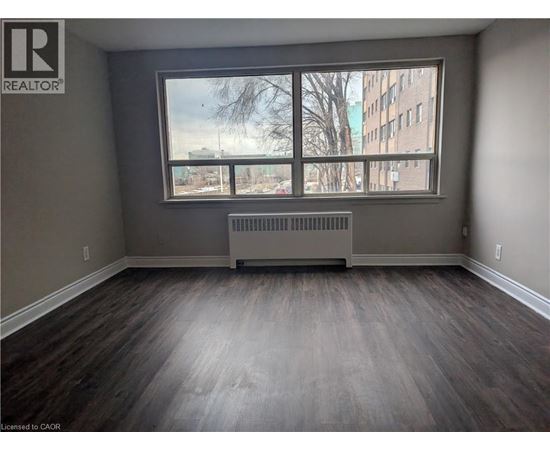 A room with a large window and a radiator on the floor.