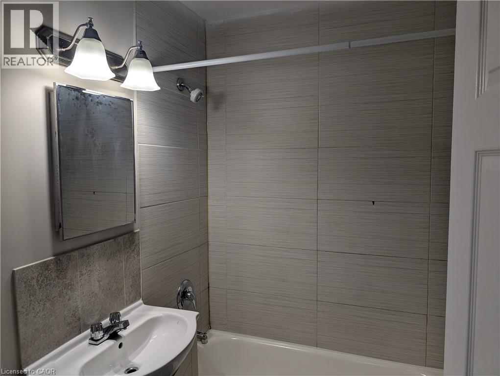 A bathroom with a white sink and a white bathtub.