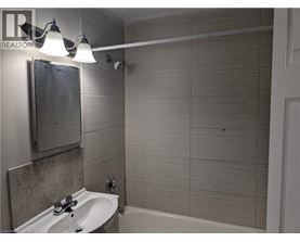 A bathroom with a white sink and a white bathtub.