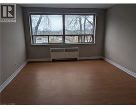 A room with a window and a radiator on the floor.