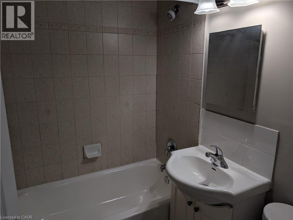 A bathroom with a white tub, sink, and toilet.