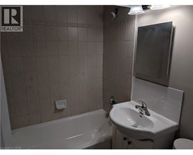 A bathroom with a white tub, sink, and toilet.