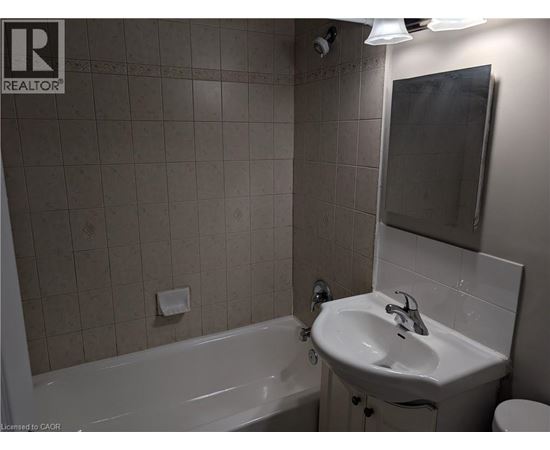 A bathroom with a white tub, sink, and toilet.