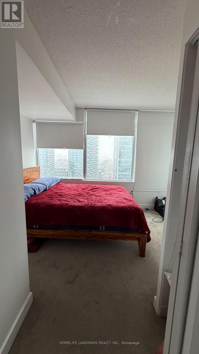A bedroom with a bed and a window with blinds.