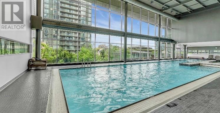 A large indoor swimming pool with a view of the outside through the windows.