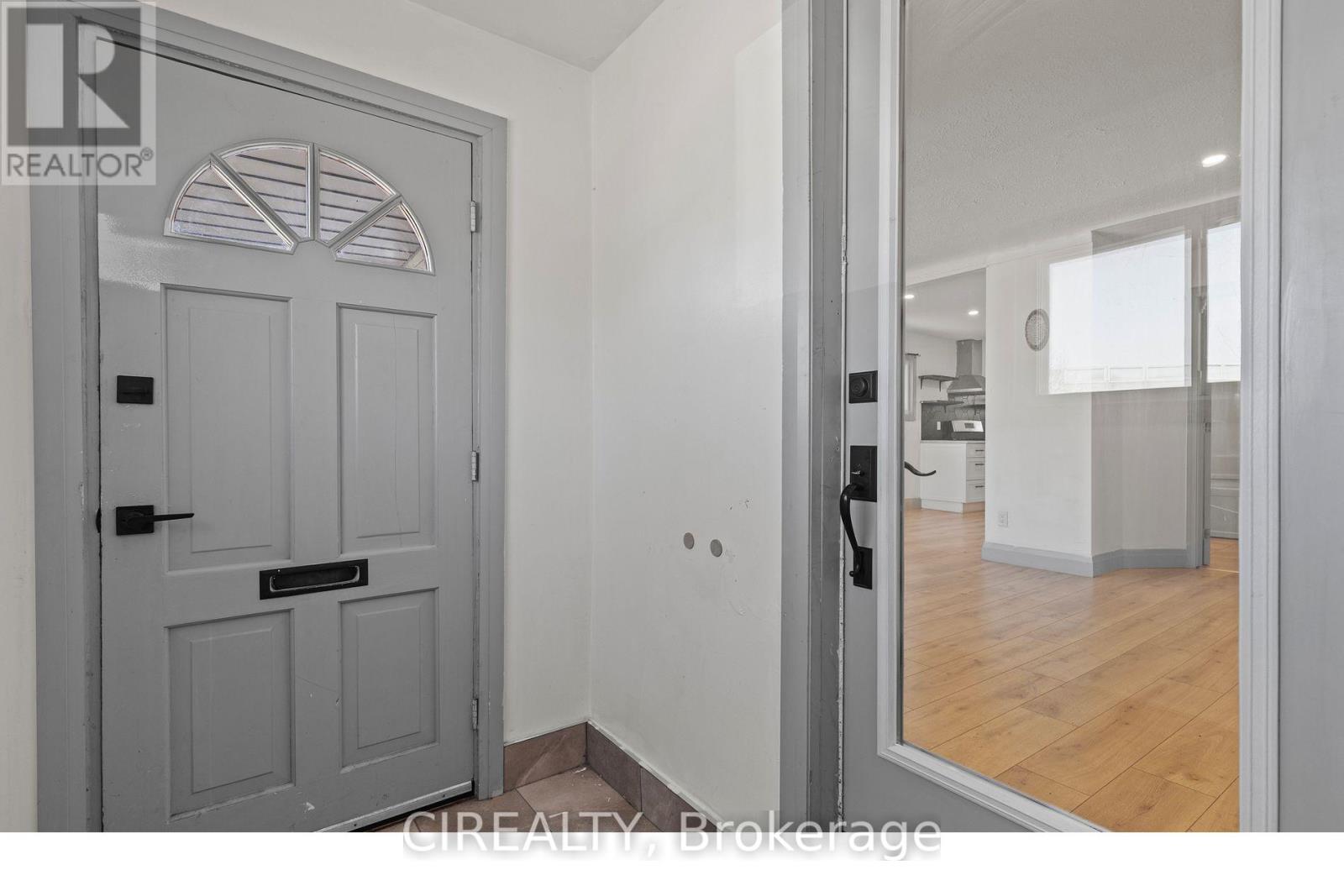 A grey door with a black handle is in a room with white walls.