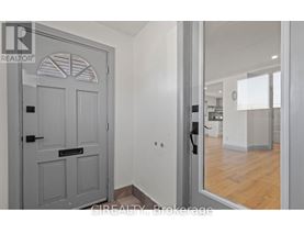 A grey door with a black handle is in a room with white walls.