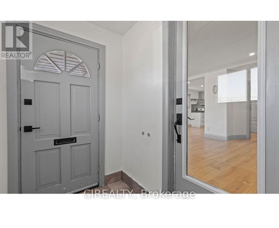 A grey door with a black handle is in a room with white walls.