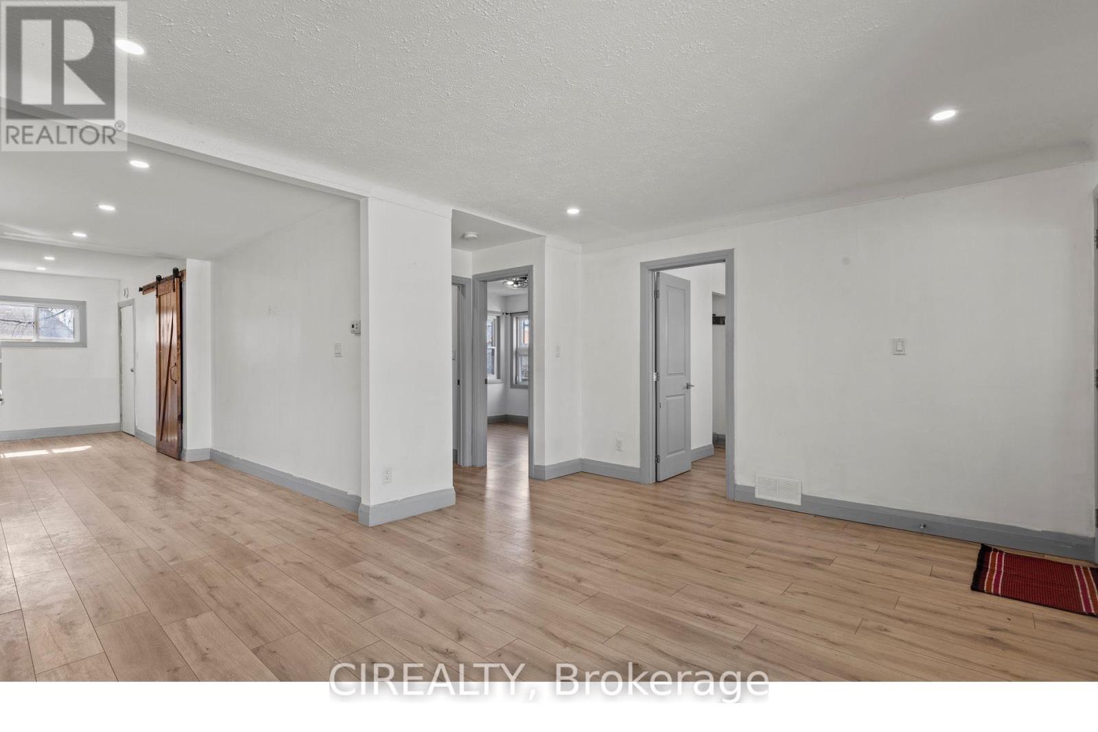 A large empty room with wooden floors and white walls.