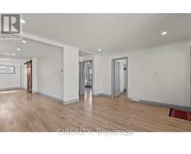A large empty room with wooden floors and white walls.