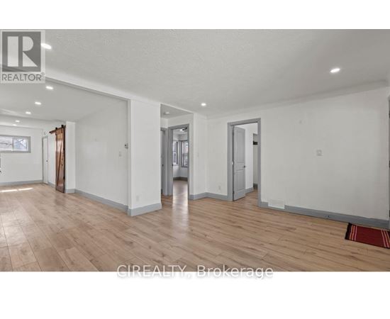 A large empty room with wooden floors and white walls.