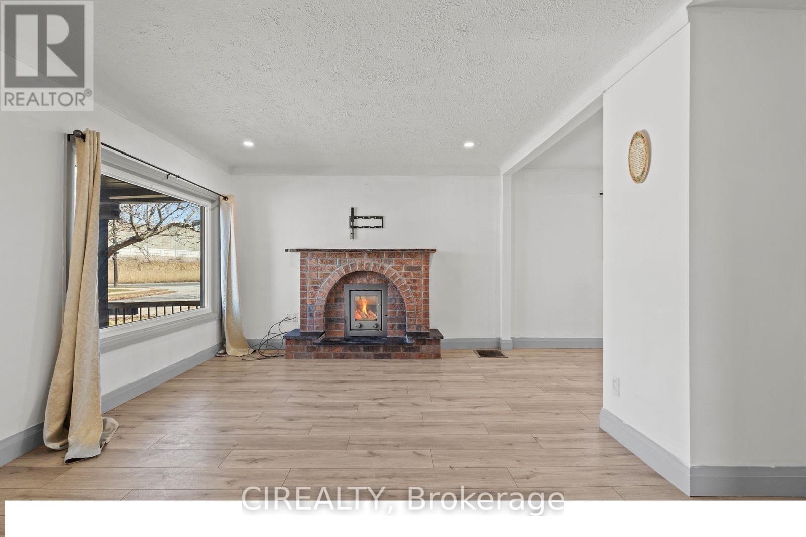 A room with a fireplace and a window with curtains.