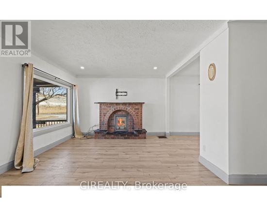 A room with a fireplace and a window with curtains.