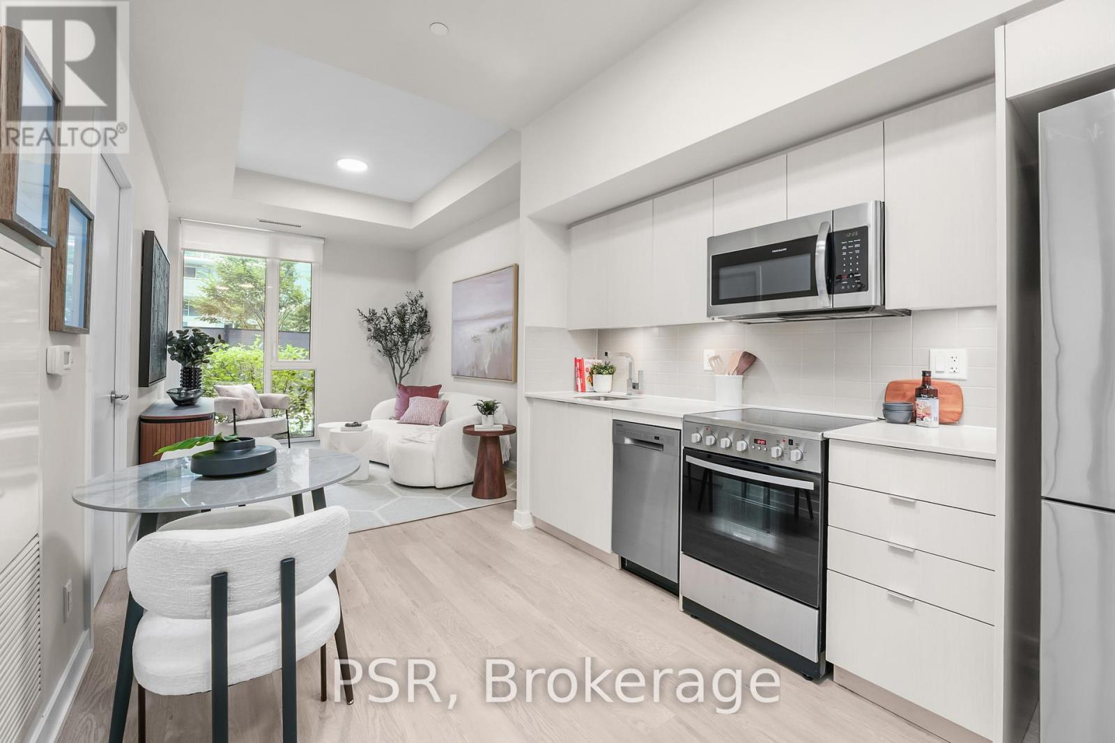 A modern kitchen with white cabinets and stainless steel appliances.