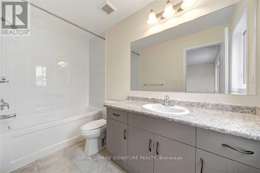 A bathroom with a white toilet, sink, and bathtub.