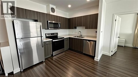 A modern kitchen with a refrigerator, oven, and microwave.