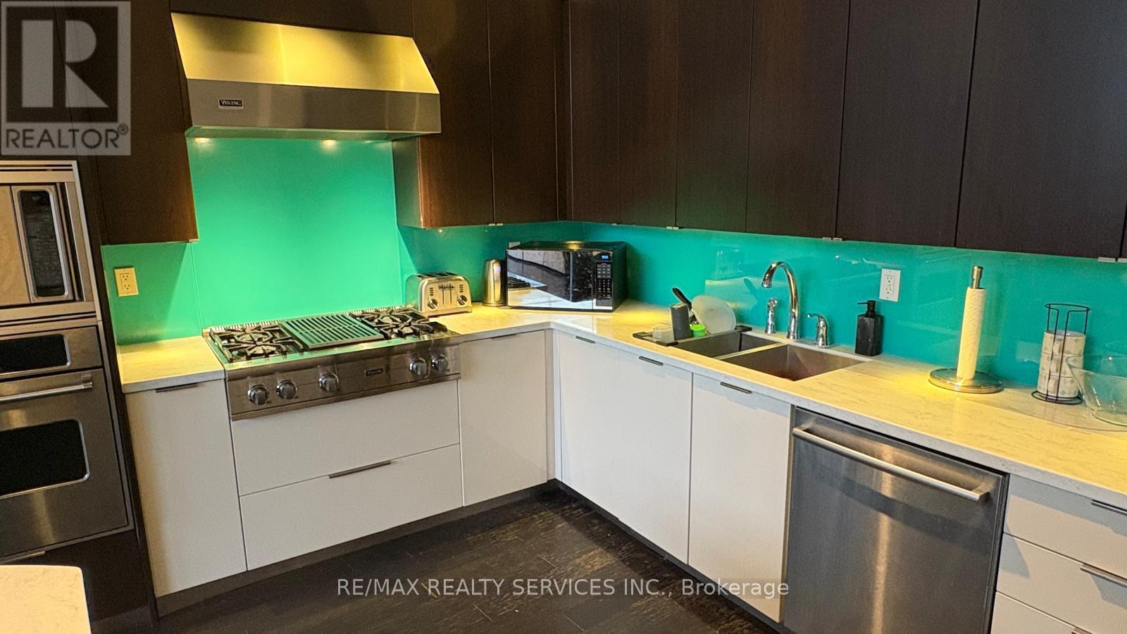 A kitchen with a stove top oven and a sink.