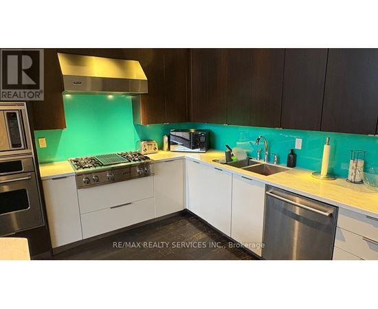 A kitchen with a stove top oven and a sink.