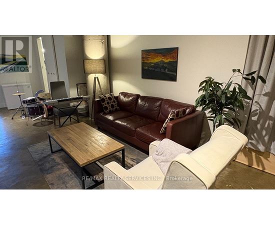 A living room with a brown leather couch and a wooden coffee table.