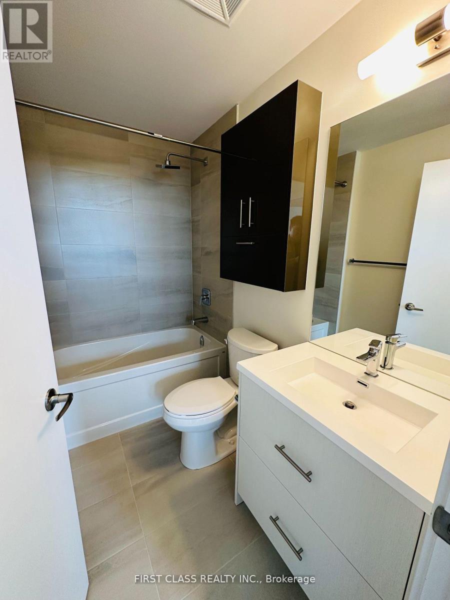 A bathroom with a white toilet, sink, and a black cabinet.