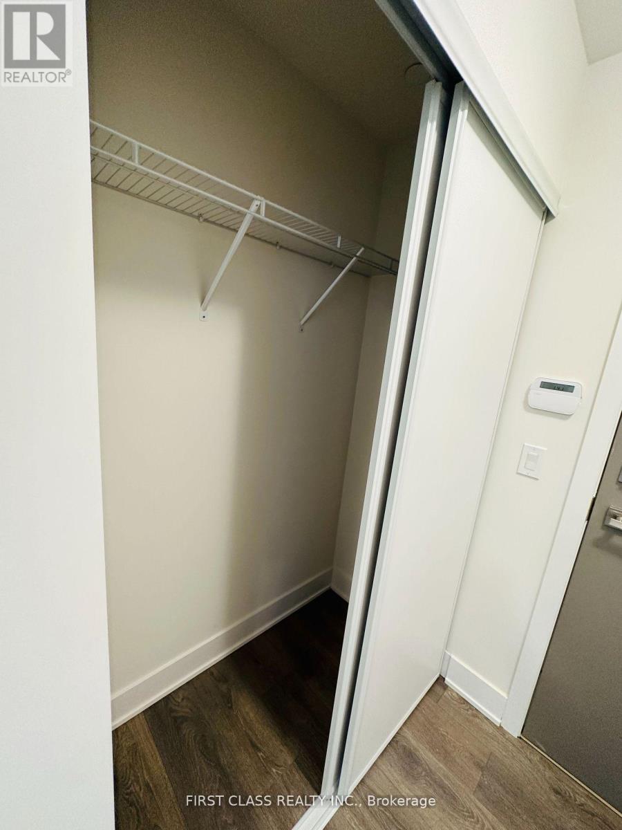 A white closet with a white door and a white shelf.