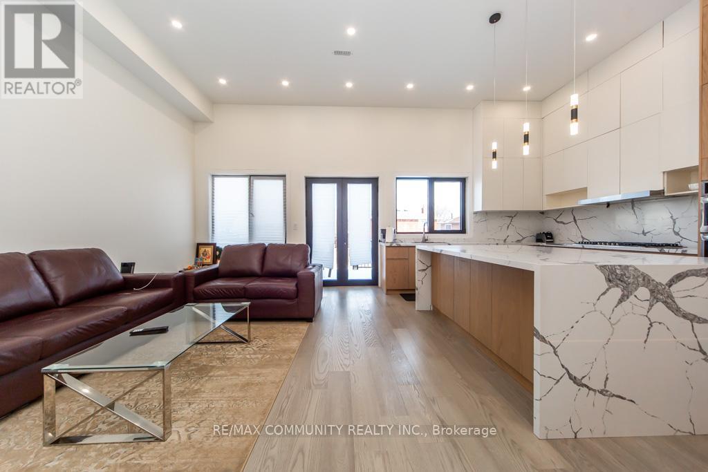 A modern living room with a brown leather couch and a marble countertop.