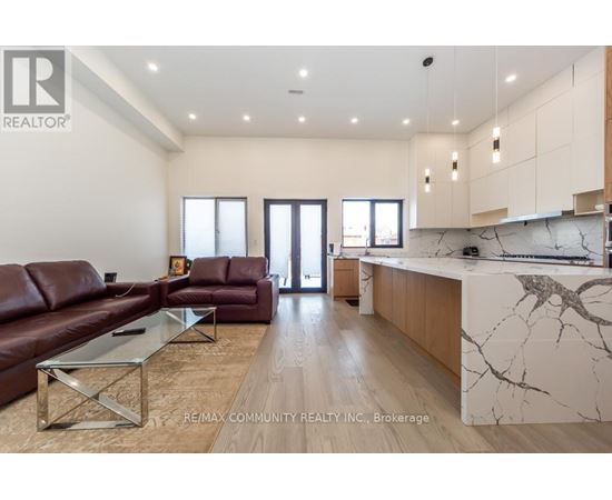 A modern living room with a brown leather couch and a marble countertop.