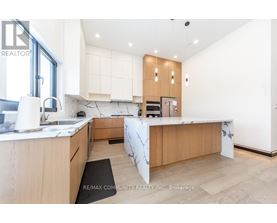 A modern kitchen with wooden cabinets and a marble countertop.