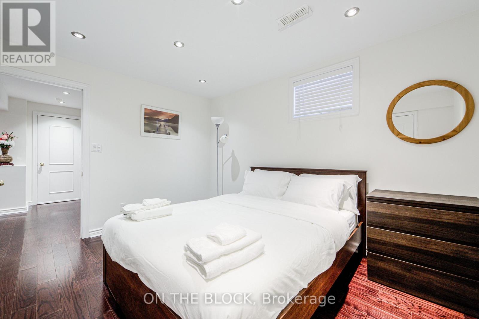 A bedroom with a large bed and a wooden headboard.